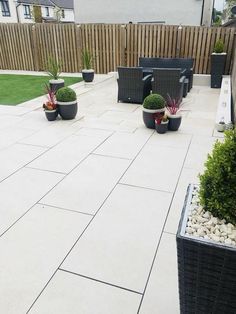 an outdoor patio with chairs and potted plants