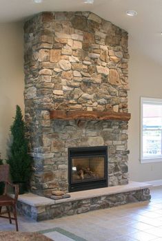 a living room with a stone fireplace and chairs