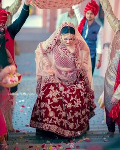 the bride is getting ready to walk down the aisle with her family and friends behind her