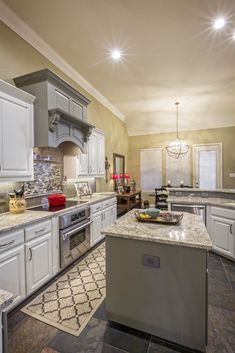 a large kitchen with white cabinets and granite counter tops