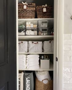 an organized closet with baskets and folded towels