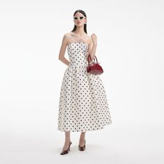 For partygoers after a hearty dose of vintage chic, this polka dot taffeta dress falls from a timeless bandeau neckline to a flattering dropped waist and full photo-ready midi skirt. Fitted style, take one size up if between sizes This style has minimal stretch Zip closure at back Removable shoulder straps Hidden pocke Strapless Puffy Midi Dress, Daring Dress, Taffeta Fabric, Taffeta Dress, Dress Fitted, Fitted Style, Product Images, Dot Dress, Chic Dress