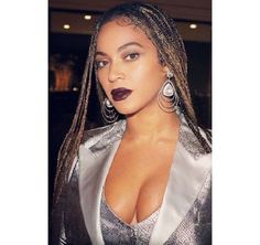 an image of a woman with dreadlocks on her head wearing a silver dress