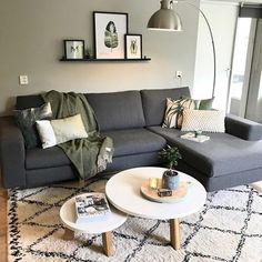 a living room with grey couches and white coffee table in front of a large window