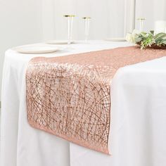 a white table topped with a pink and gold runner