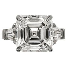 an emerald cut diamond ring with three baguets on the shoulders and side stones