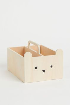 a wooden box with a bear's face on the front, and two eyes on the back