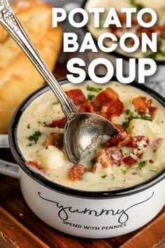 two white bowls filled with soup on top of a wooden table next to some bread