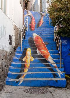 there is a painting on the steps that has gold fish painted on it and blue stairs