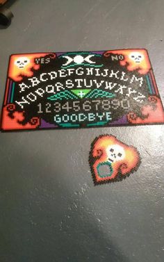 a cross stitch pattern with the letters and numbers on it, in front of a computer mouse