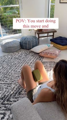 a woman laying on the floor reading a book