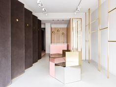 an empty room with pink, gold and white furniture on the floor in front of brown partitions