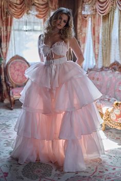 Embrace the wild beauty of the frontier in this enchanting two-piece ensemble. The slinky slip dress, adorned with a flirtatious bow-tied bust, pairs perfectly with a flowing tiered skirt. An extra-long satin ribbon closure adds a touch of frontier elegance. In a desert rose pink as tender as a cowboy's heart, this ens Pink Angels, Tiered Gown, Cosplay Inspiration, Ruffle Maxi Skirt, Skirt Swimsuit, Princess Core, Wild Beauty, Tiered Maxi Skirt