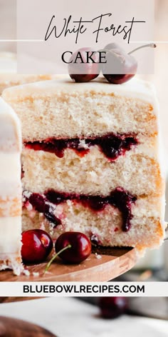 a white frosted cake with cherries on top