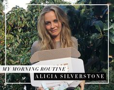 a woman standing in front of trees holding a box with the words my morning routine written on it