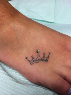 a foot with a small crown tattoo on it