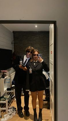 a man and woman taking a selfie in the mirror