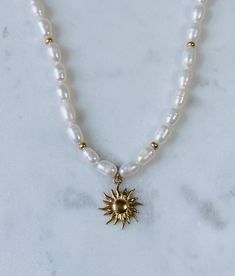 Chunky necklace with large freshwater rice pearls and small galvanized gold beads. Charm is a large gold sun or clamshell pendant. Necklace is 16 inches in length and includes a 2 inch extender. Gold Pearl Beaded Charm Necklaces, Rice Pearls, Chunky Pearls, Sun Charm, Beads Charm, Gold Sun, Gold Charm Necklace, Chunky Necklace, Detail Shop