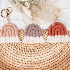 three tasseled keychais on top of a woven basket