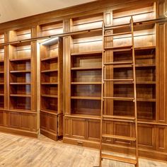 an empty room with wooden shelves and ladders