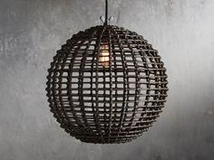 a light that is hanging from a wire on a wall with concrete walls in the background