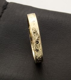 a close up of a gold ring on a black surface