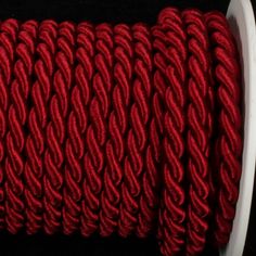 a spool of red rope on a black background