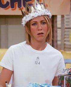 a woman wearing a crown sitting at a table