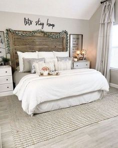 a bedroom with white bedding and wooden headboard in the middle of the room