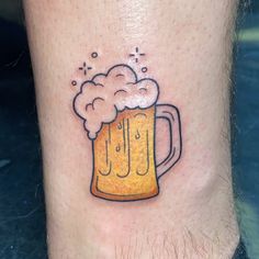 a tattoo on the leg of a man with a mug of beer and bubbles coming out of it