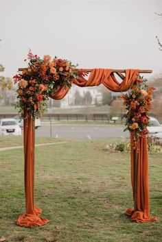 an orange wedding arch decorated with flowers