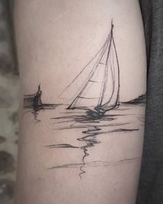 a black and white photo of a sailboat in the water on a woman's thigh