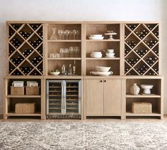 a wine rack in the middle of a room with many bottles and glasses on it