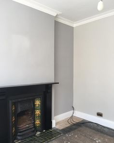 an empty living room with a fireplace in the corner