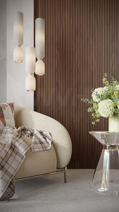 a living room filled with furniture and flowers on top of a glass table in front of a wooden wall