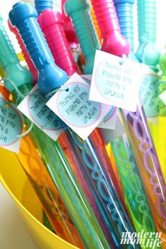 there are many different colored toothbrushes in the yellow cup with tags on them