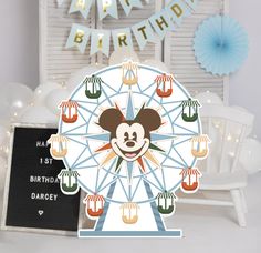 there is a birthday card with a mickey mouse face on it and a ferris wheel in the background