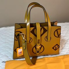 Valentino Handbags Under License Of Mario Valentino Spa Made In Italy Milano Color Yellow Gold. 15 Inches Wide. 15 Inches Tall. 5 Inches Wide. Bag Strap 35 Inches Luxury Yellow Bag With Top Carry Handle, Yellow Rectangular Bag With Branded Hardware, Yellow Rectangular Bags With Branded Hardware, Yellow Travel Bag With Branded Hardware, Designer Yellow Bag With Top Carry Handle, Luxury Yellow Shopping Bag, Light Luxury Gold Bags For Shopping, Light Luxury Gold Bag, Gold Light Luxury Shopping Bag