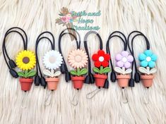 six flower clips are lined up on a white furnishing with flowers in them