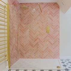 a bathroom with pink tiles and gold fixtures