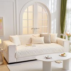 a living room with white furniture and green curtains