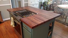 a kitchen island with an oven in the middle and wooden counter tops on both sides