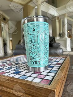 the yet tumbler is sitting on top of a mosaic tile table in a living room