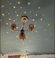 a chandelier hanging from the ceiling in a room with stars painted on it