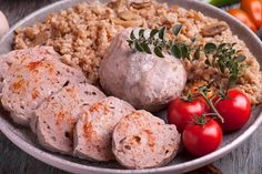 a white plate topped with meat, rice and tomatoes