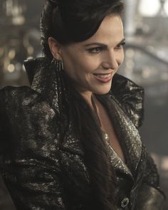 a woman wearing a black jacket and smiling at the camera