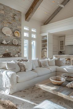 a living room filled with white furniture and lots of pillows on top of it's couches