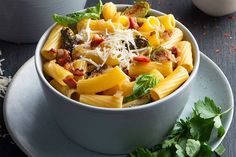 two bowls filled with pasta and vegetables on top of a table