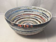 a bowl made out of magazines sitting on top of a table