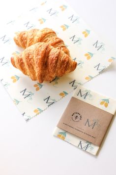 two croissants sitting on top of a table next to a business card